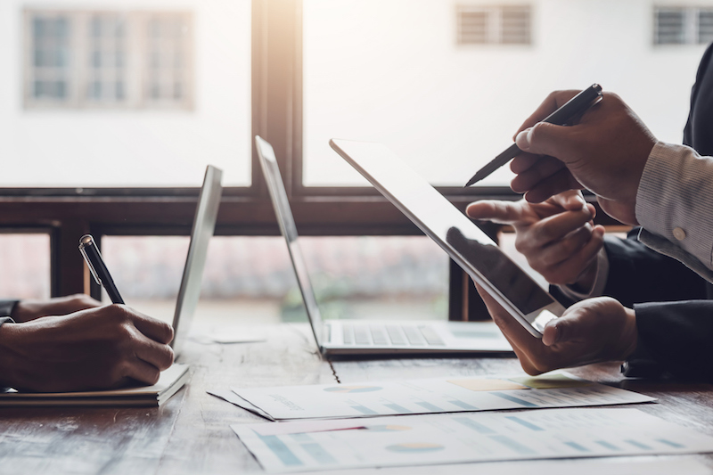 Group of business people meeting, discussing, analyzing graphs, financial data, and planning a marketing project together. Group of business people meeting, discussing, analyzing graphs, financial data, and planning a marketing project together.