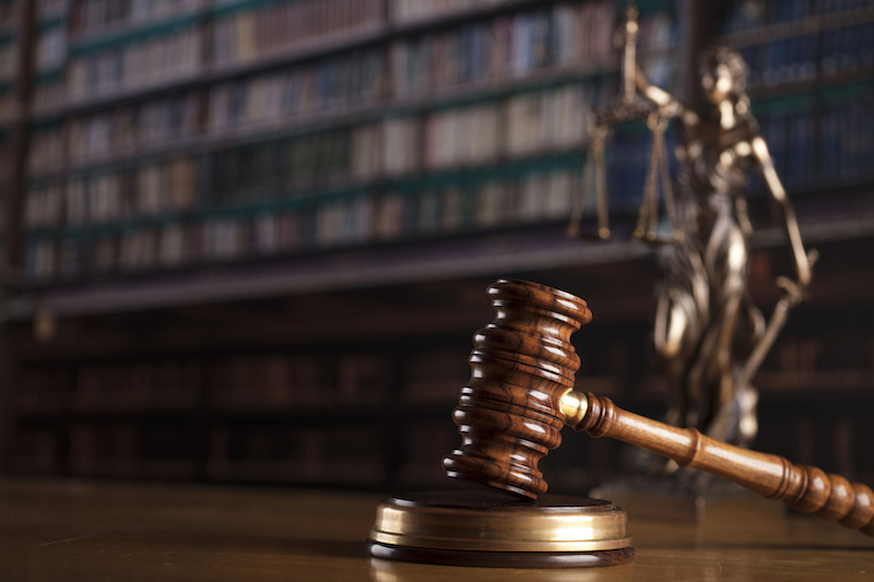 Law concept. Gavel and Themis statue in the court library.