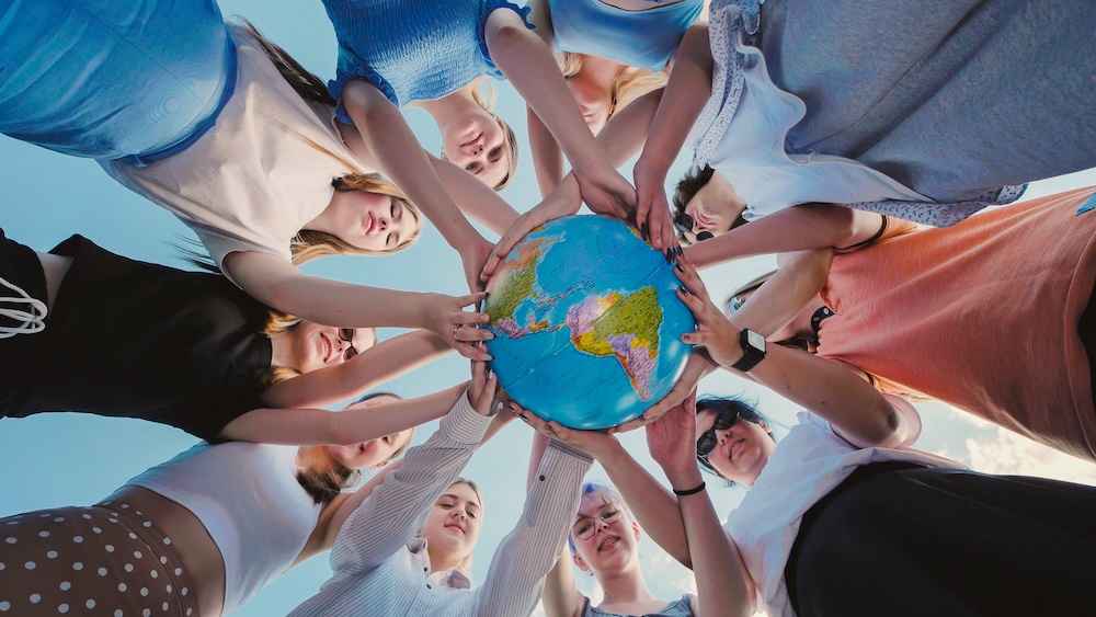 School friends united in holding a globe, representing global solidarity and commitment to environmental stewardship, advocating for sustainability and earth responsibility